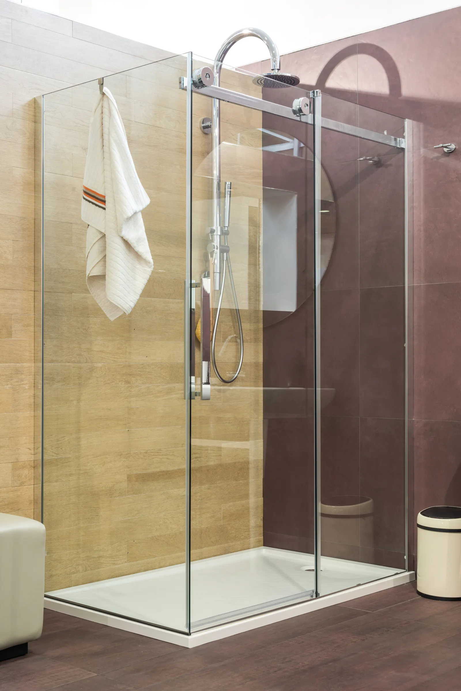 Corner shower with chrome-framed sliding glass doors and a low white shower tray.