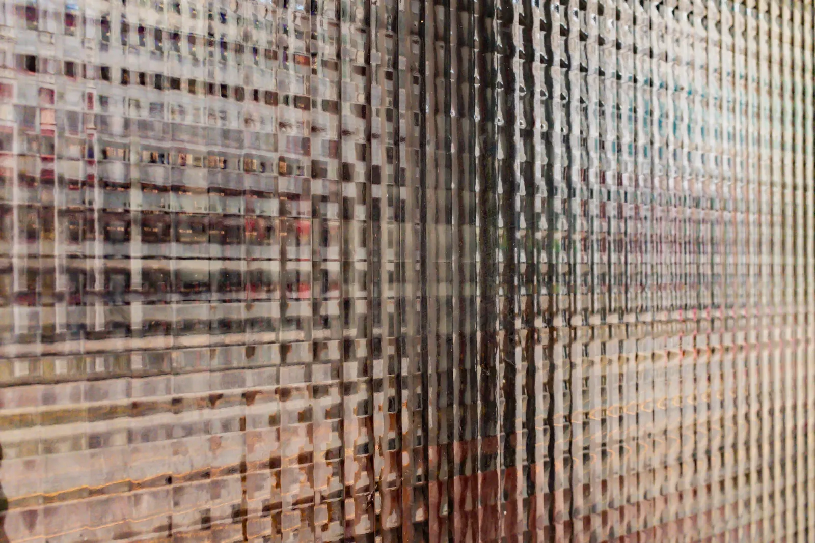 Textured grid-patterned glass close-up distorting a city view behind it.