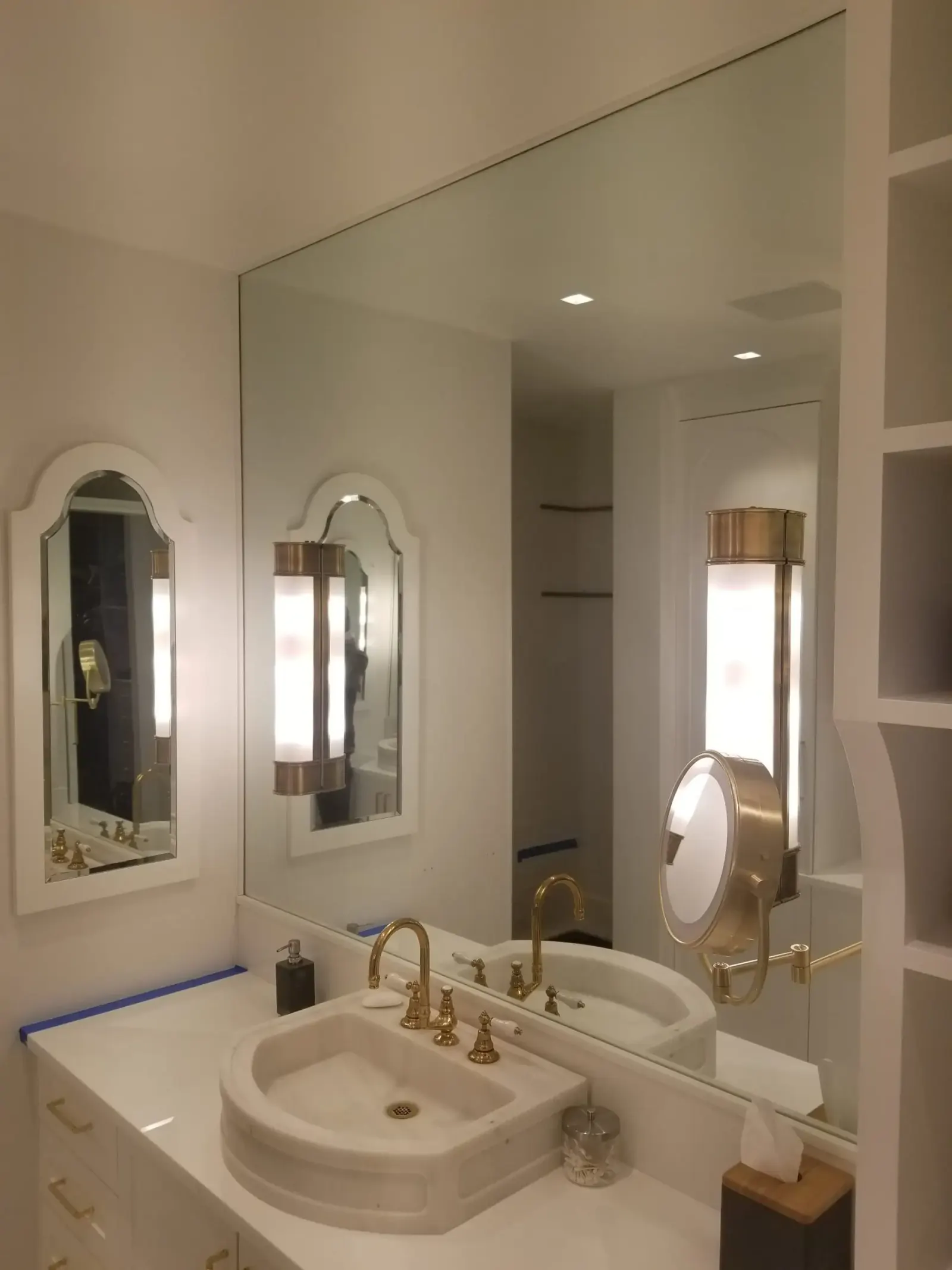 Large bathroom vanity mirrors installed between wall sconces.
