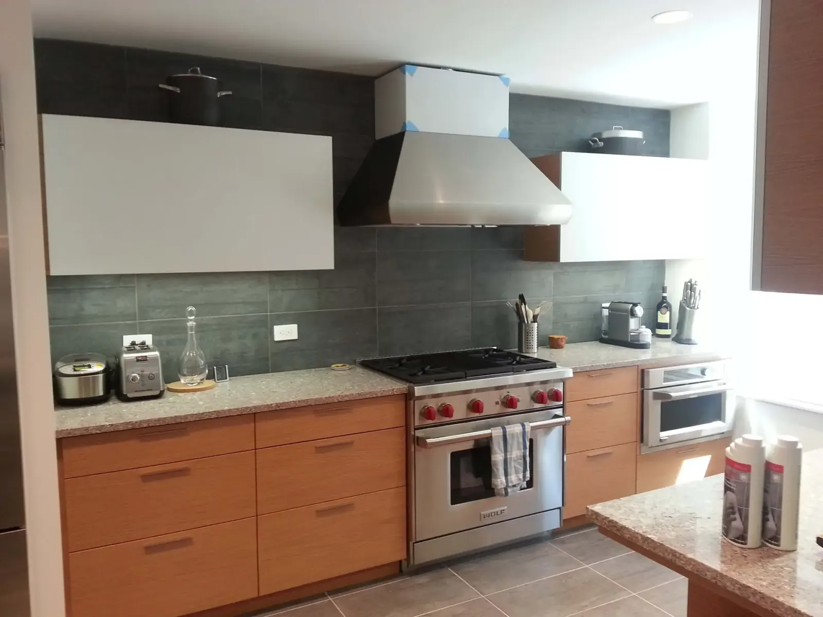Mirrored glass kitchen backsplash behind a stainless range.