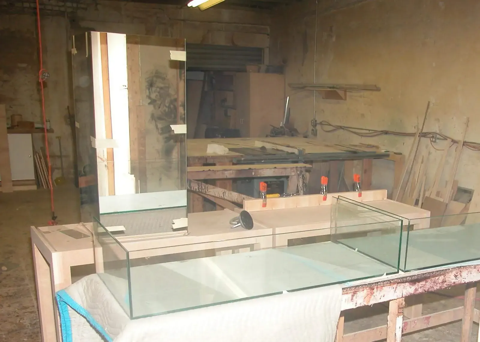Custom glass display cases arranged in a fabrication workshop.