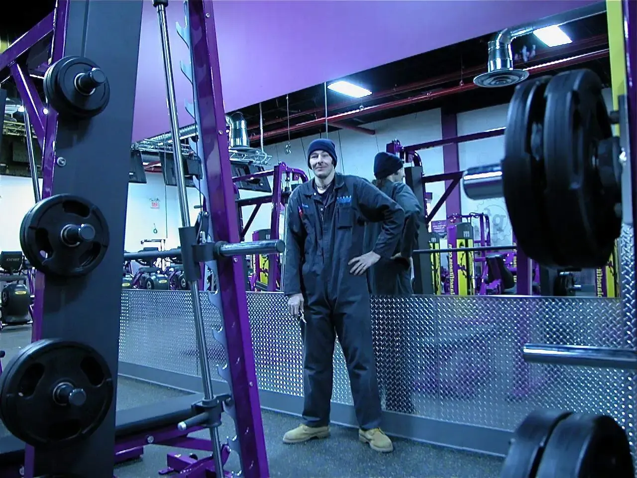 Brooklyn Shower Doors team member beside a mirrored gym wall.